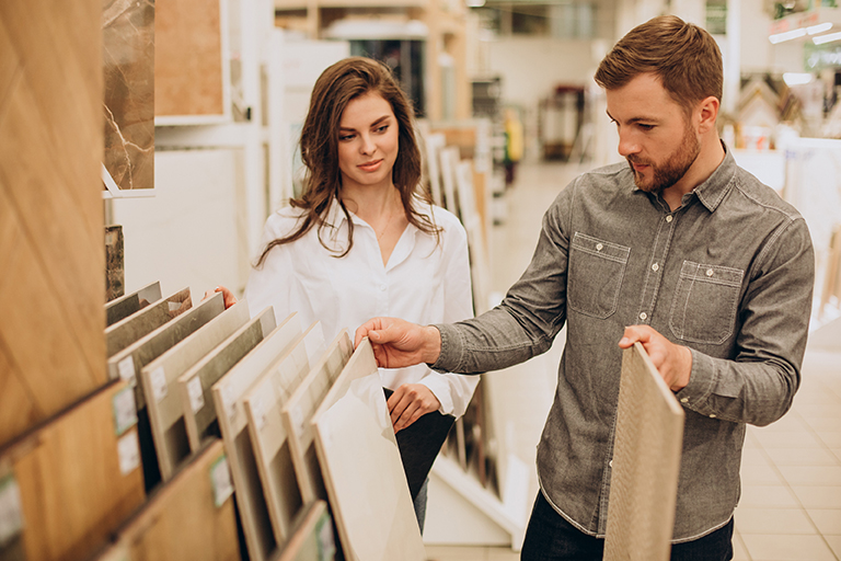 Young couple choosing tiles at building market